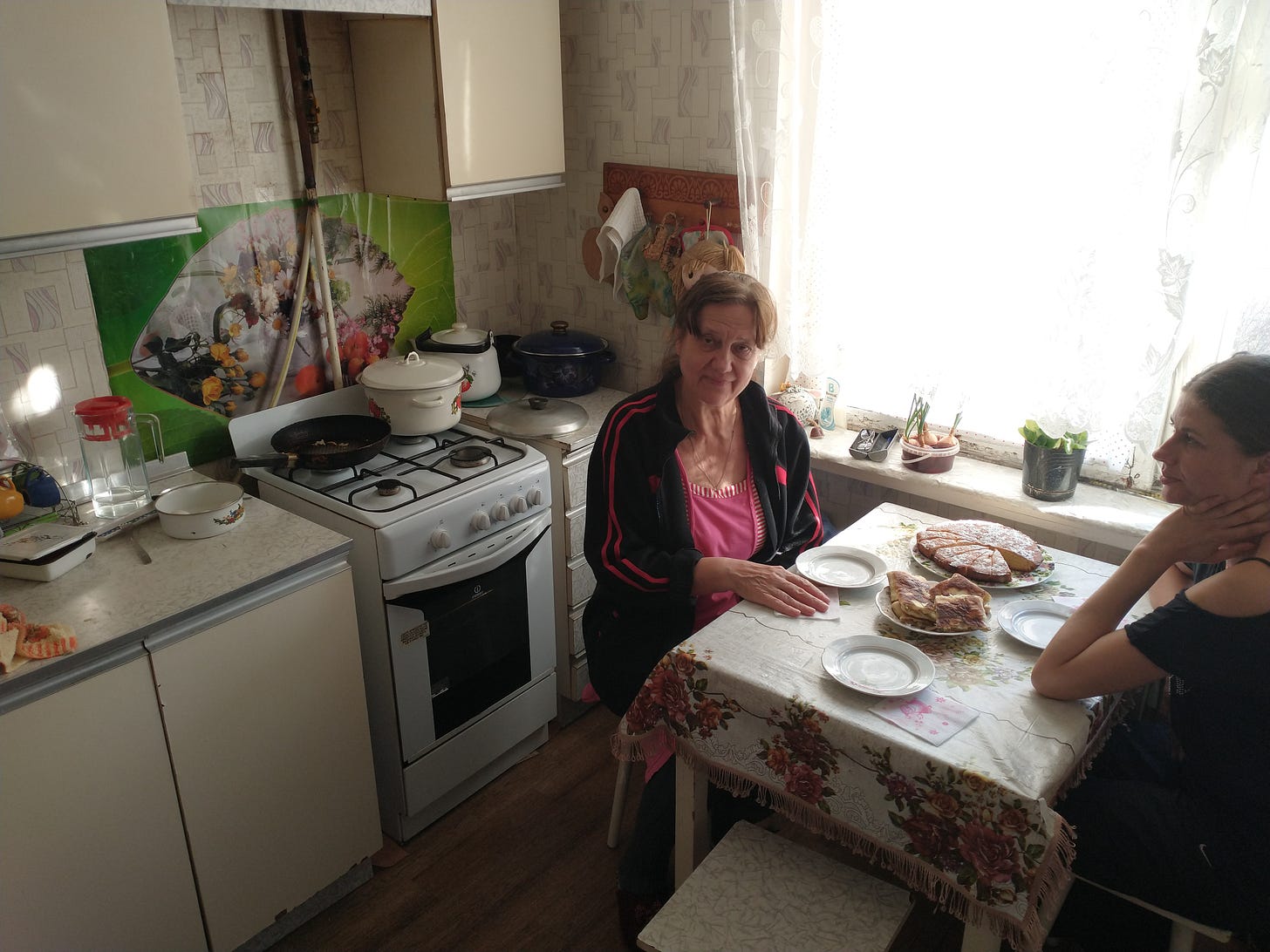 Olga sits with her daughter in their kitchen in Odessa. She has prepared Latkes and cake.