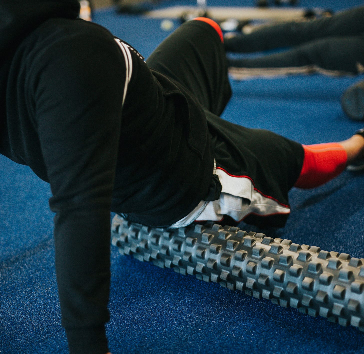 a man using a foam roller in a gym