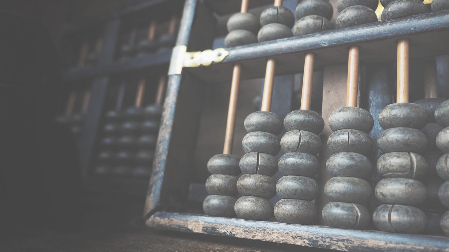 An old fashioned wooden abacus with beads on a white background, used for counting and mathematical calculations.