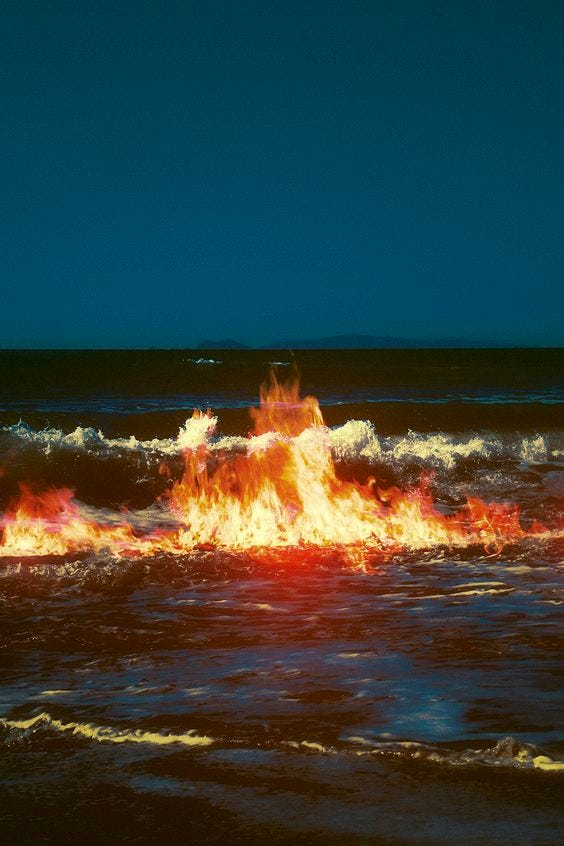 fotografia colorida de um oceano pegando fogo