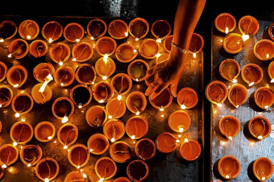 A Hindu devotee holds an oil lamp while offering prayers during Diwali, the festival of lights, at a Hindu temple in Colombo, Sri Lanka, on Nov. 4, 2021.