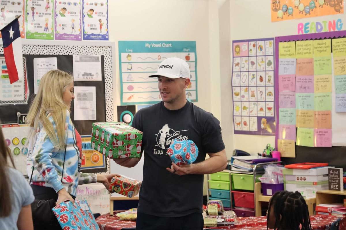 Astros third baseman Alex Bregman and his wife Reagan help distribute toys to students at Spring Branch ISD's Thornwood Elementary School on the afternoon of Dec. 16 as part of a partnership event with Lily's Toy Box.
