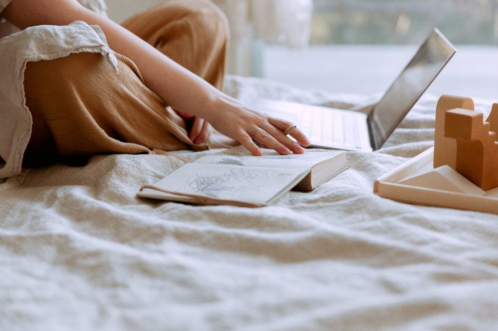 woman using a laptop on a bed