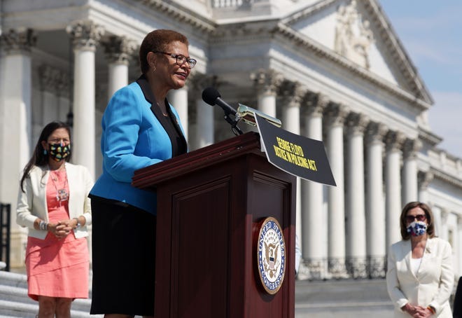 U.S. Rep. Karen Bass (D-CA) speaks as Speaker of the House Rep. Nancy Pelosi (D-CA) listens during an event on police reform June 25, 2020 at the east front of the U.S. Capitol in Washington, DC.