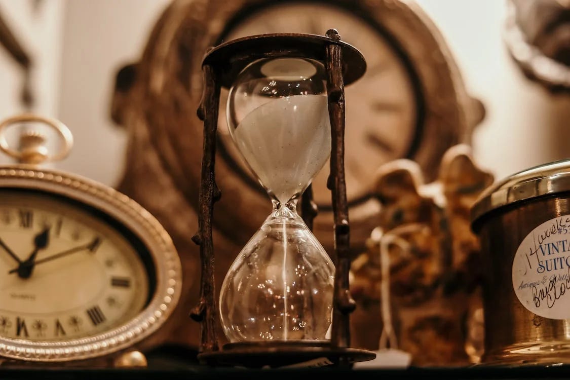 Pexels photo of an hourglass with other clocks in the background by Jordan Benton.