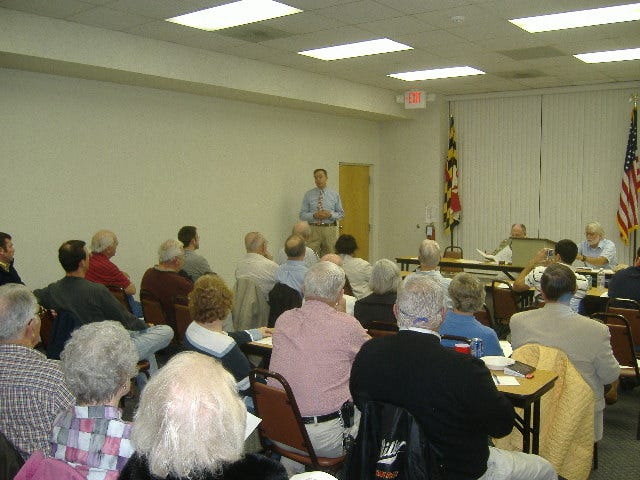 The audience sits in rapt attention listening to Andy Harris speak.