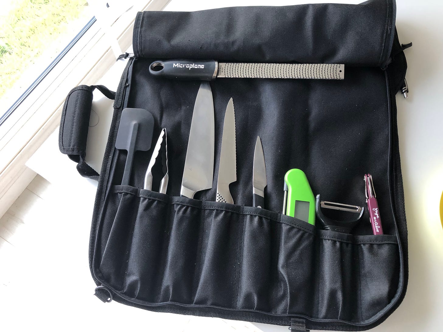 A nylon knife roll containing essential kitchen equipment