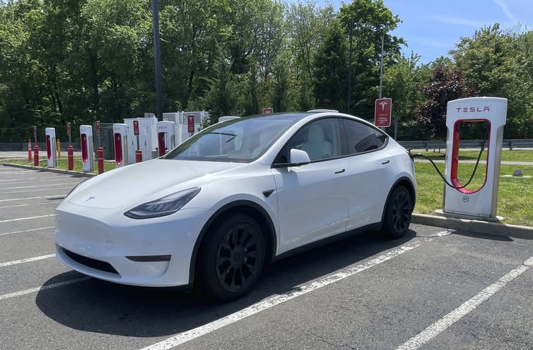 An electric car charging at a Tesla station