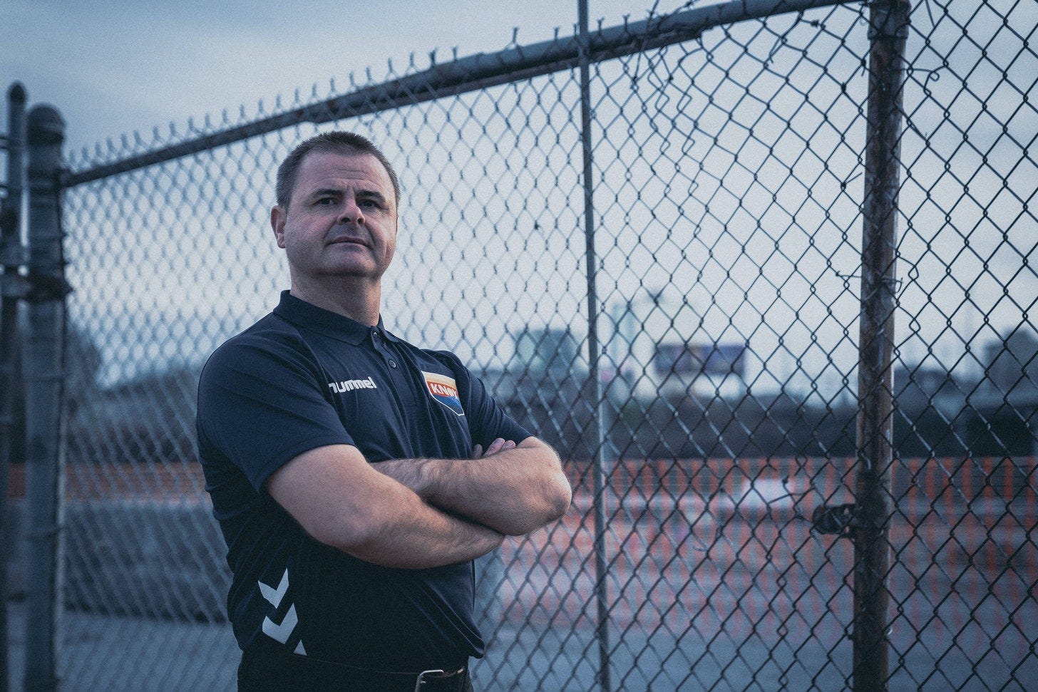 Mark McKeever stands beside a chainlink fence outside of the future site of Knoxville's Old City stadium.