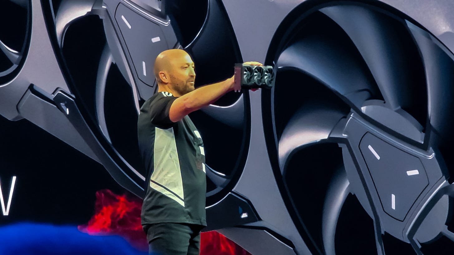 man holding up graphics card on a stage