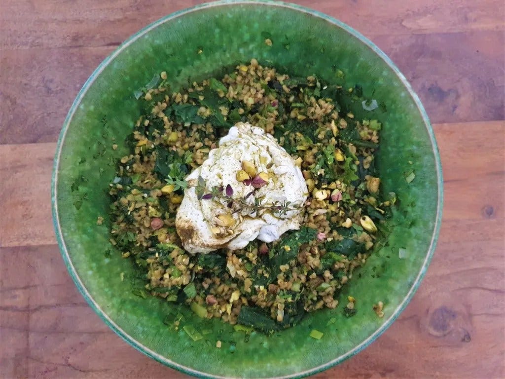 A green dish with the finished recipe of Freekeh Herb Salad with Labane Dressing