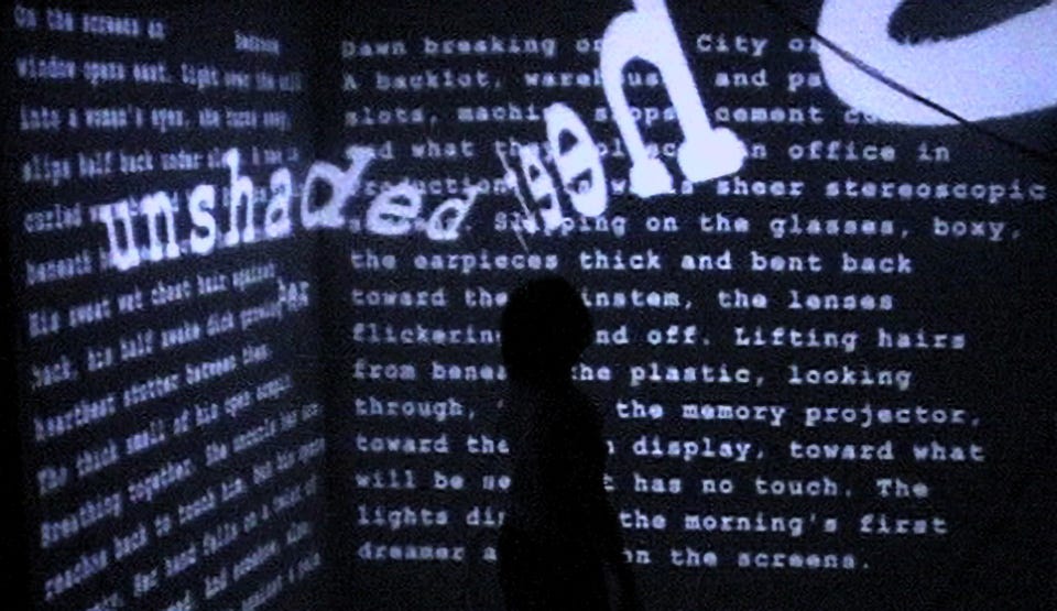 A silhouetted figure against a black wall of white words, two of which appear to be floating free.