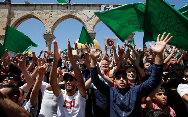 Palestinians wave flags of the Hamas terror group after afternoon prayers for the last Friday of the holy Muslim month of Ramadan, on the Temple Mount in Jerusalem's Old City, May 7, 2021. (Jamal Awad/Flash90)