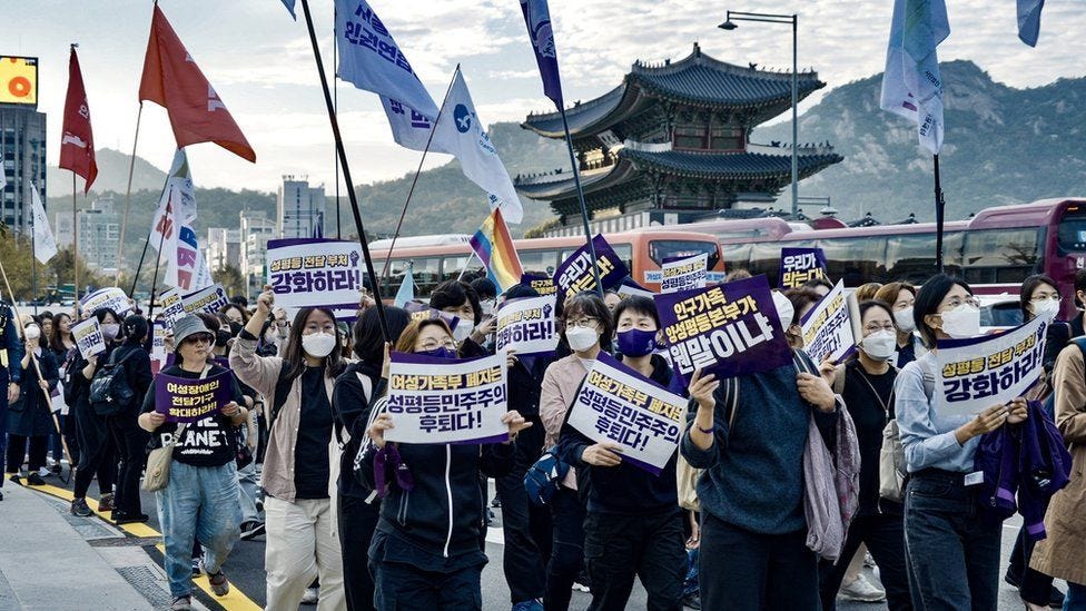 Women in Seoul hold signs protesting against the government's plans to abolish the Gender Equality Ministry