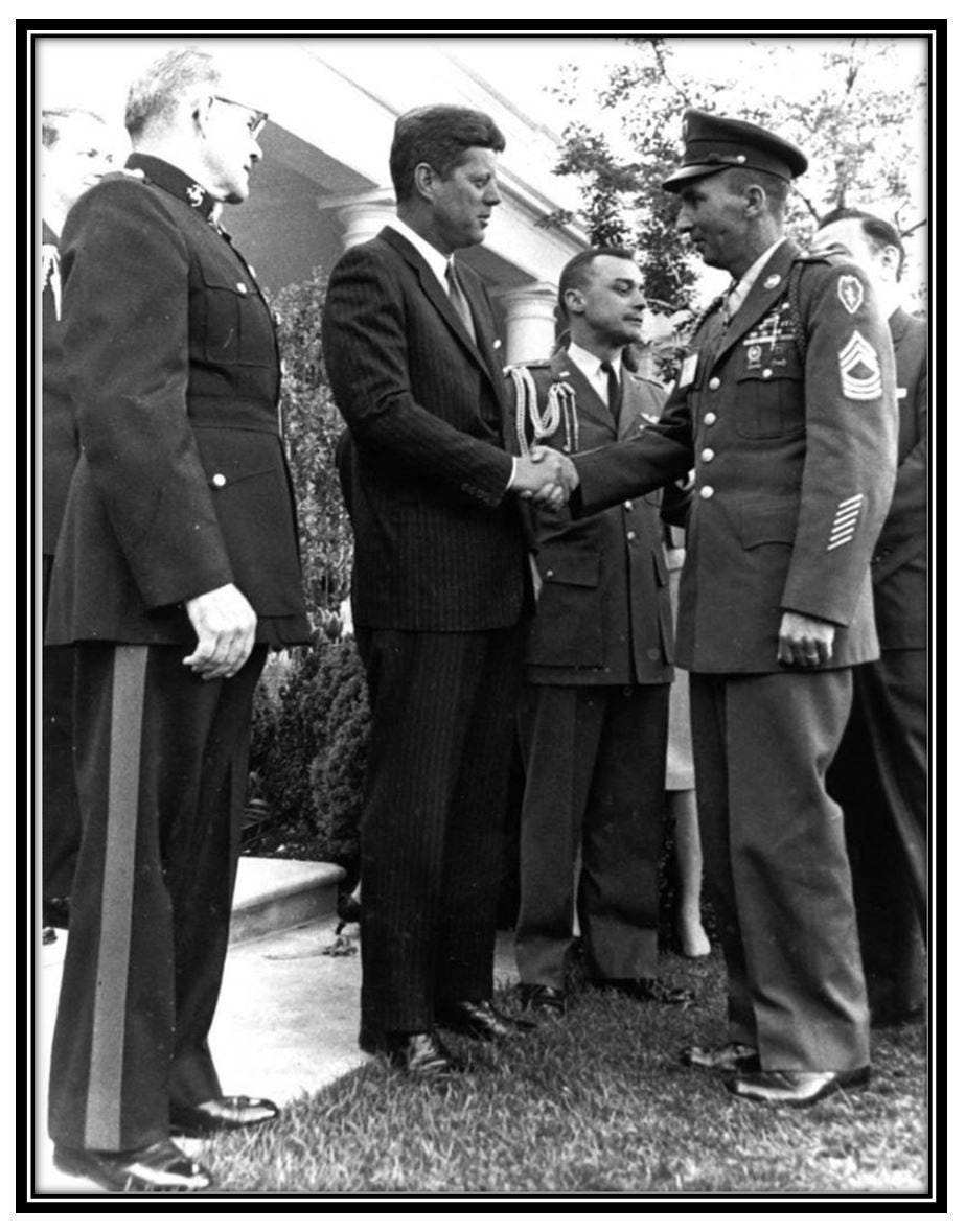 Ross is shown shaking hands with John F. Kennedy.  He is wearing his uniform and Medal. They are attending a reception that Kennedy hosted on May 2, 1963. Living MOH recipients were invited: 290 recipients were then living and 240 attended that reception.