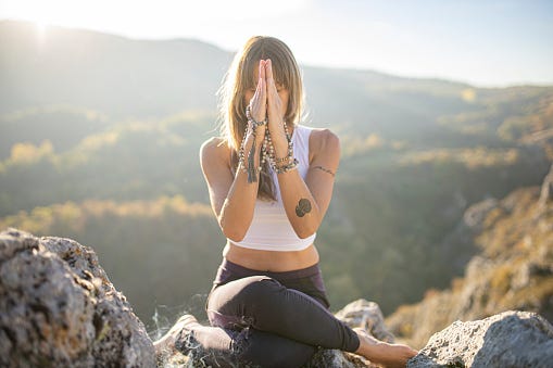 Woman meditating on mountain. 