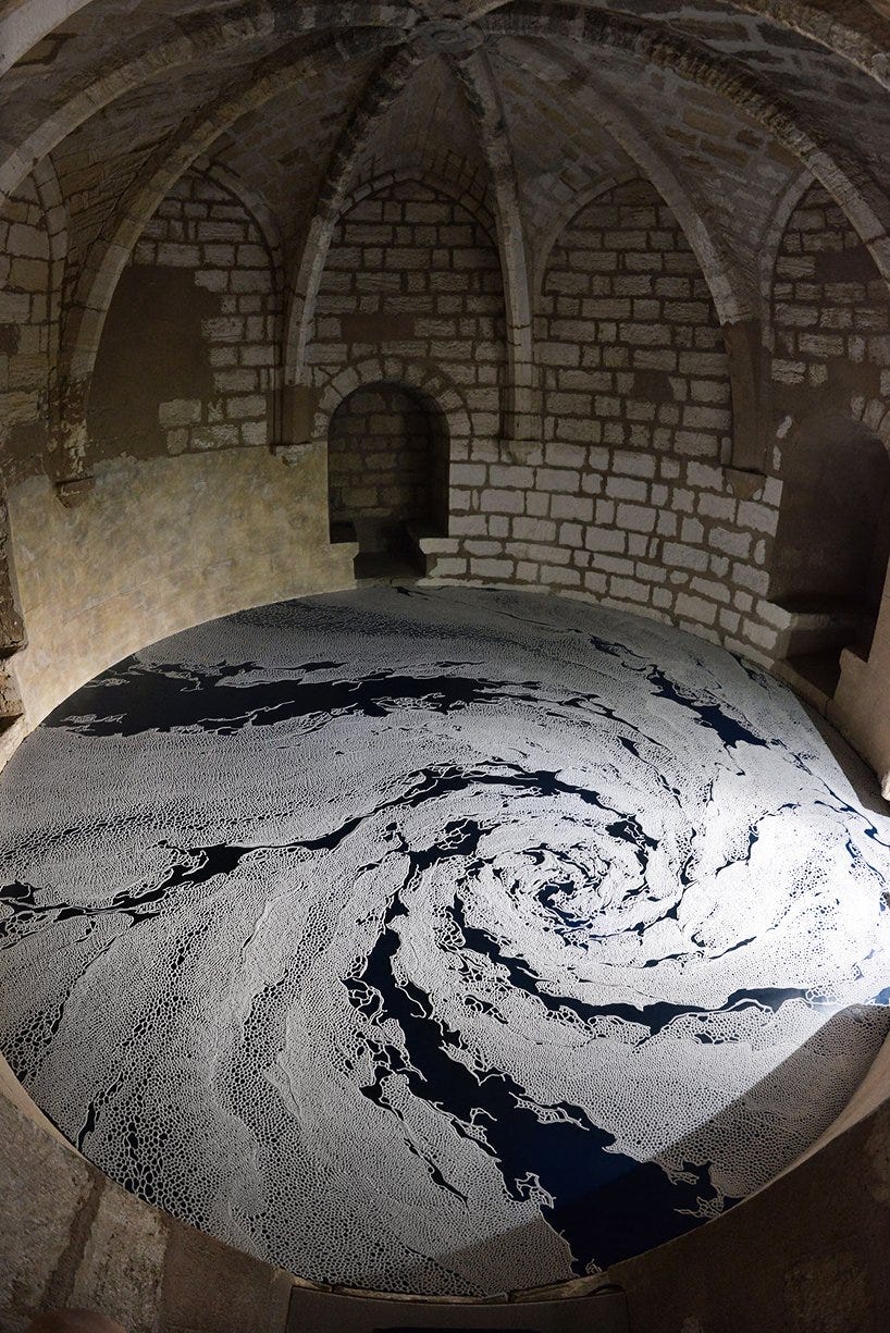Swirling maze of white salt on a blue floor in a French castle tower.