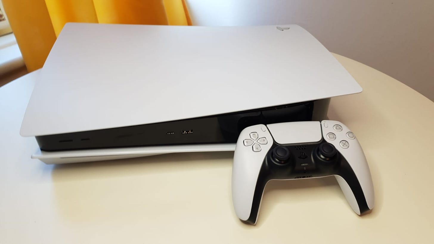 PS5 on a white table with a mustard colored curtain behind it