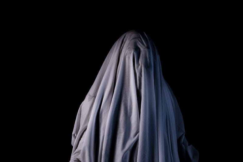 A person with a sheet over their head, a la, a ghost.