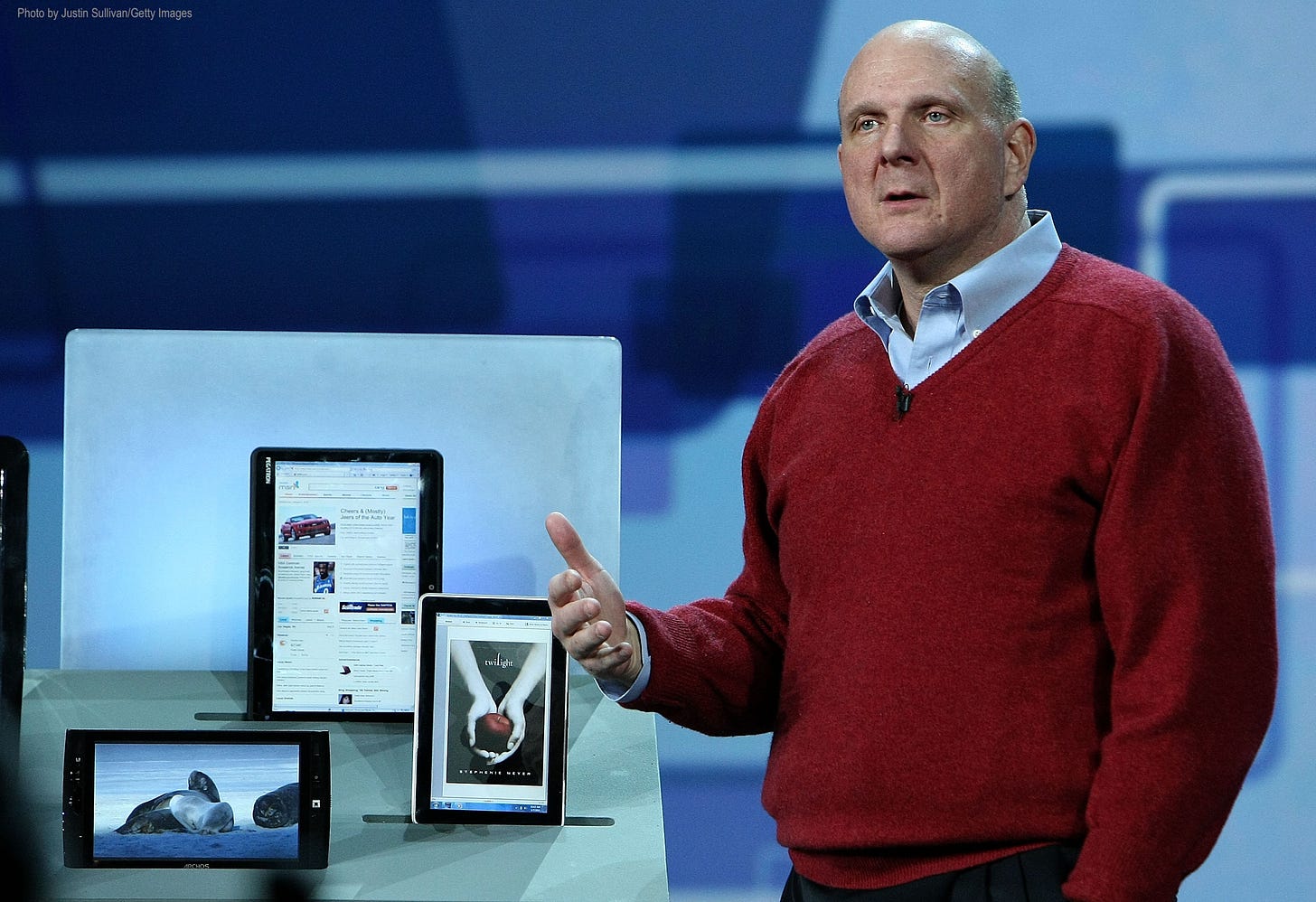Steve Ballmer on stage pointing at some Windows 7 slate computers.