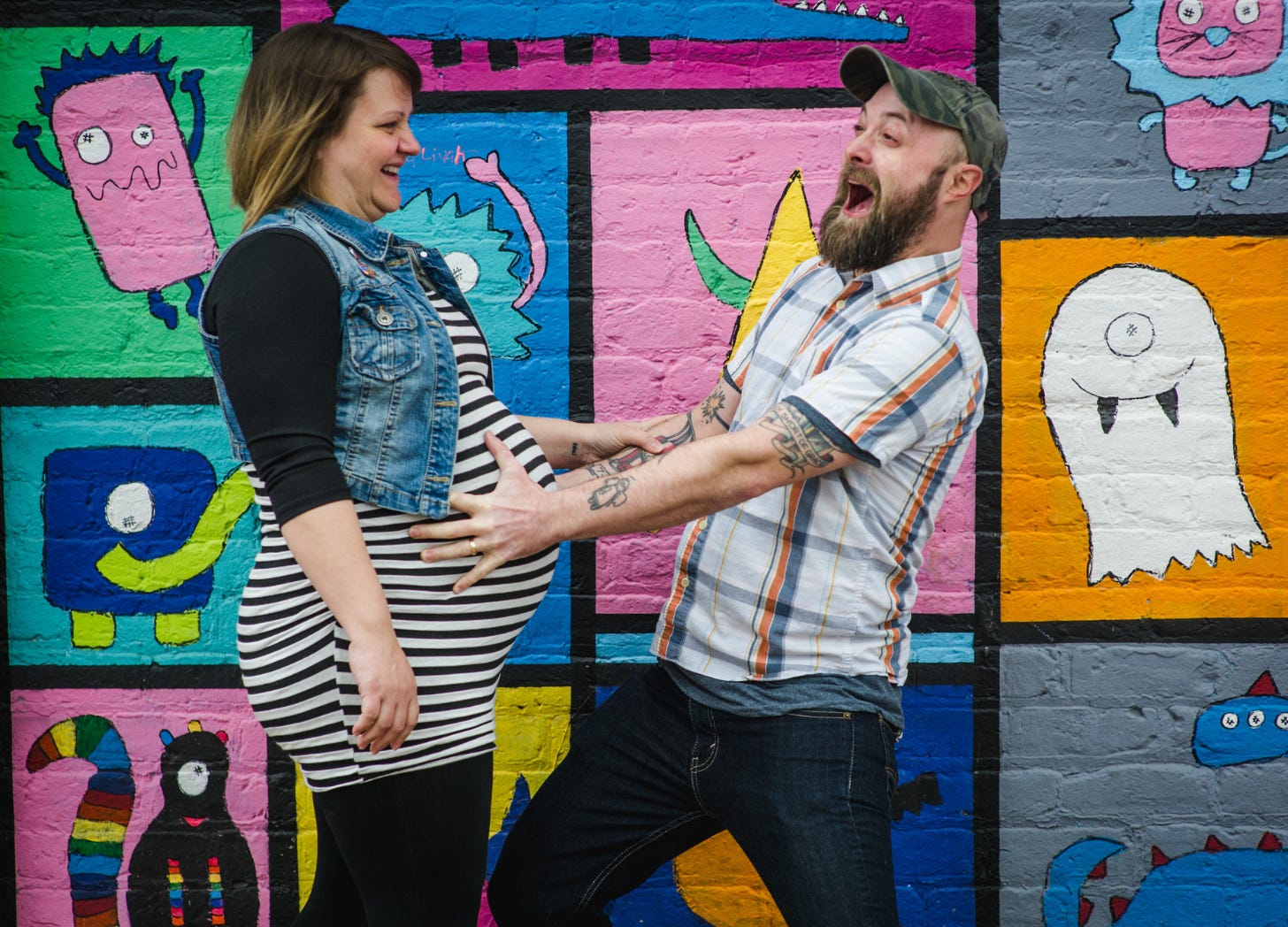 Photo of Matt holding Deanna's pregnant belly and yelling, probably gaining superpowwers. Deanna looks at him and laughs in a black and white striped dress. 