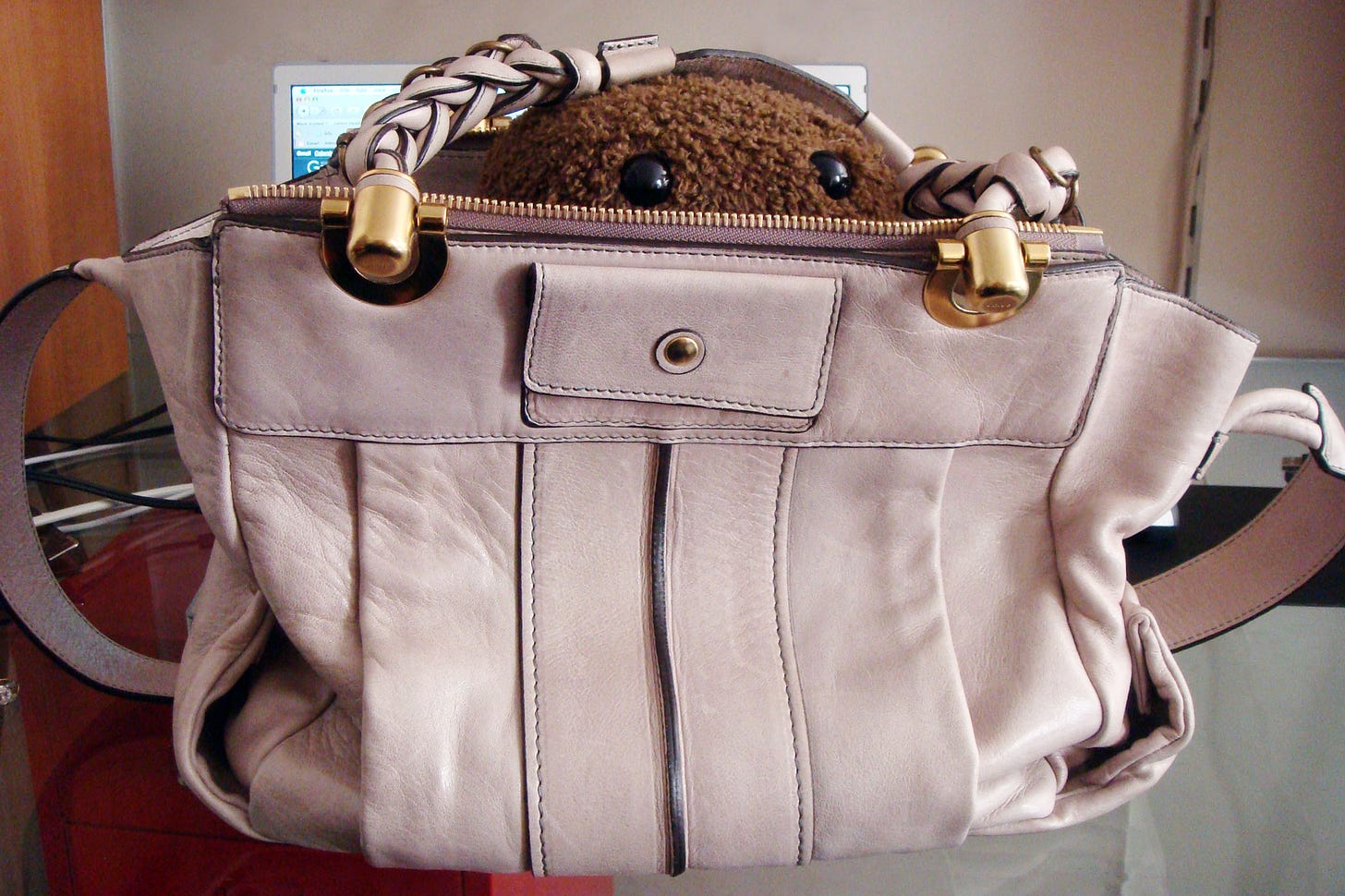 Stuffed Domokun in a designer handbag