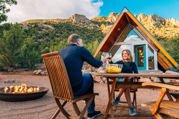 "Cheers!" Caucasian Couple Sharing a Celebratory Toast with Local Wine, Chips, and Salsa Together in a Xeriscaped Yard with a Cute Modern Xeriscaped Tiny Home in the Background Cute Middle Aged Caucasian Couple Sharing Dinner and Wine Together in Front of a Modern Xeriscaped Tiny House in the Unaweep Canyon along Highway 141 in Western Colorado near Thimble Rock Point and Uncompahgre National Forest Airbnbs stock pictures, royalty-free photos & images