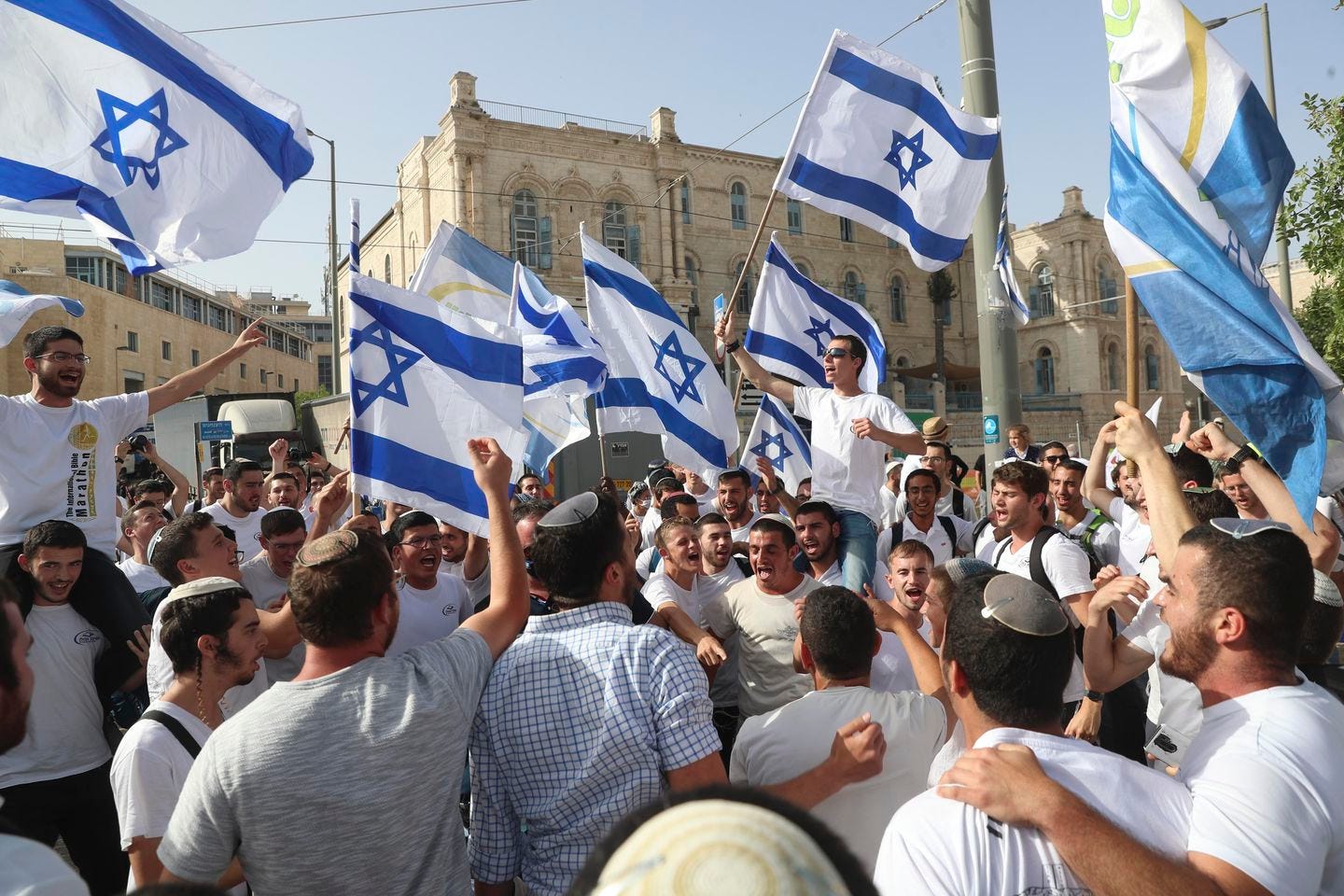 In this May 10, 2021, file photo, Israelis waved national flags during a Jerusalem Day parade, in Jerusalem. Israel’s new government on Monday approved a contentious parade by Israeli nationalists through Palestinian areas around Jerusalem's Old City, setting the stage for possible renewed confrontations just weeks after an 11-day war with Hamas militants in the Gaza Strip.