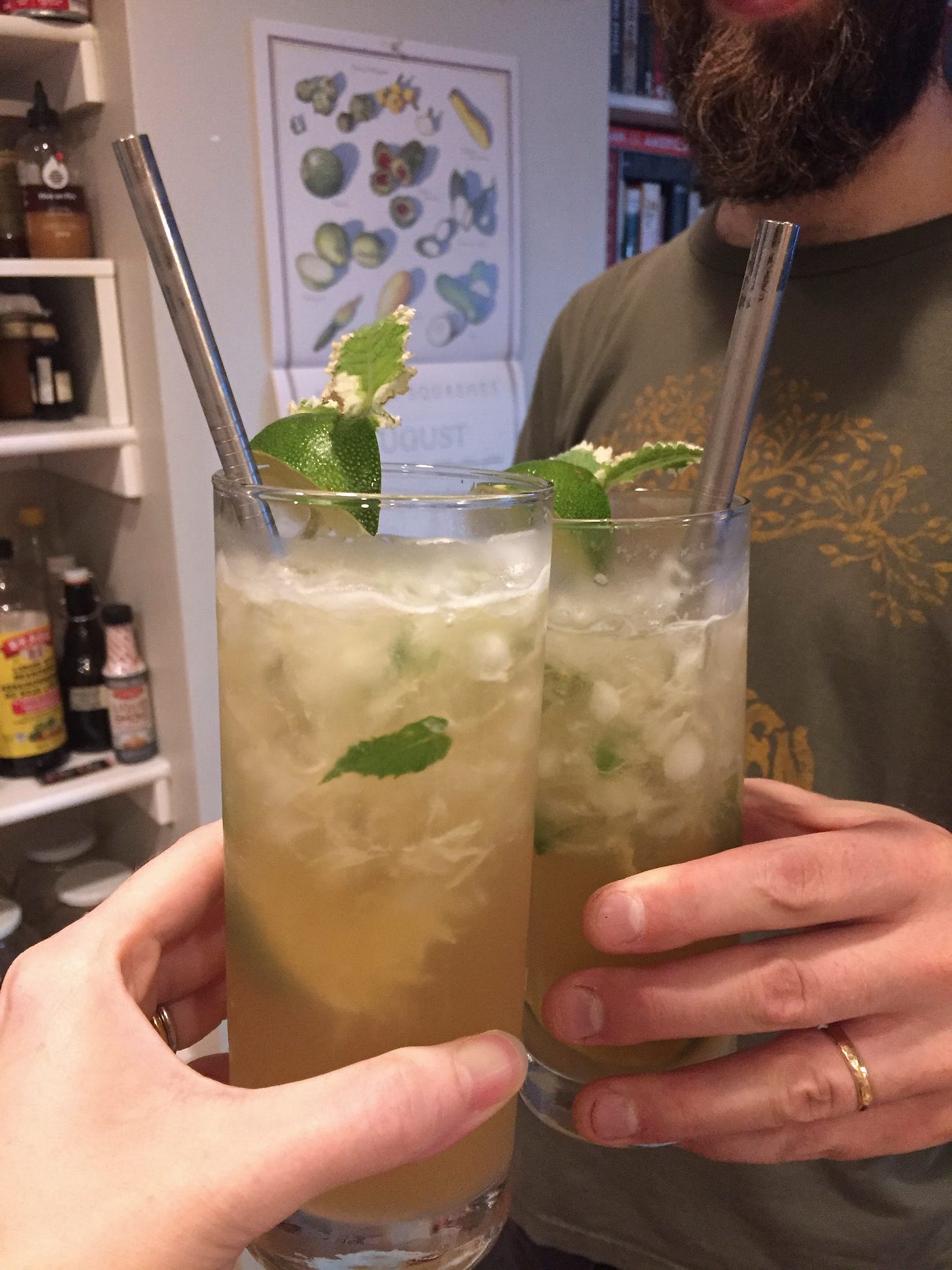 two Collins glasses with crushed ice and a pineapple mojito. Each has a lime and mint garnish and a metal straw at the top.
