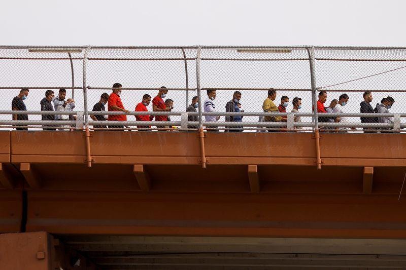 Migrantes venezolanos, expulsados de los EE UU y enviados a México bajo el Título 42, caminan a México a través del puente fronterizo internacional Lerdo-Stanton, en esta foto tomada desde Ciudad Juarez, México, el 14 de octubre de 2022. REUTERS/Jose Luis Gonzalez