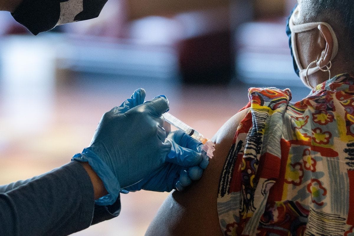 A person receives a COVID-19 vaccine earlier this year at Chicago Vocational Career Academy. Officials are urging more people to get vaccinated as the Omicron variant surfaces in Illinois.