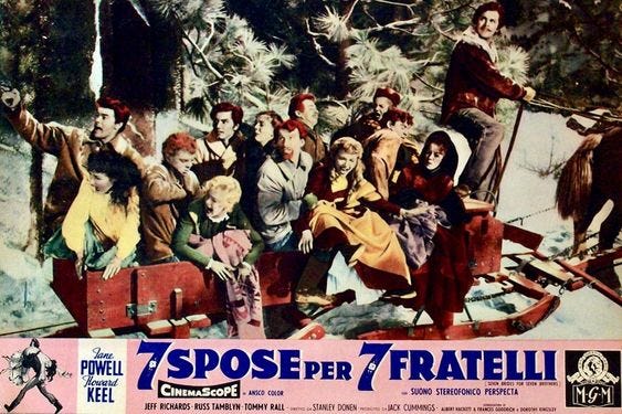Seven men and six women are in a horse drawn carriage. The men are abducting the women. The caption says 7 Spose per 7 Fratelli, Seven Brides for Seven Brothers in Italian.