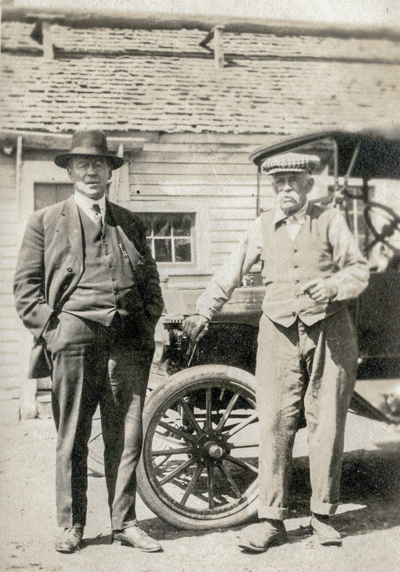 two men in front of car