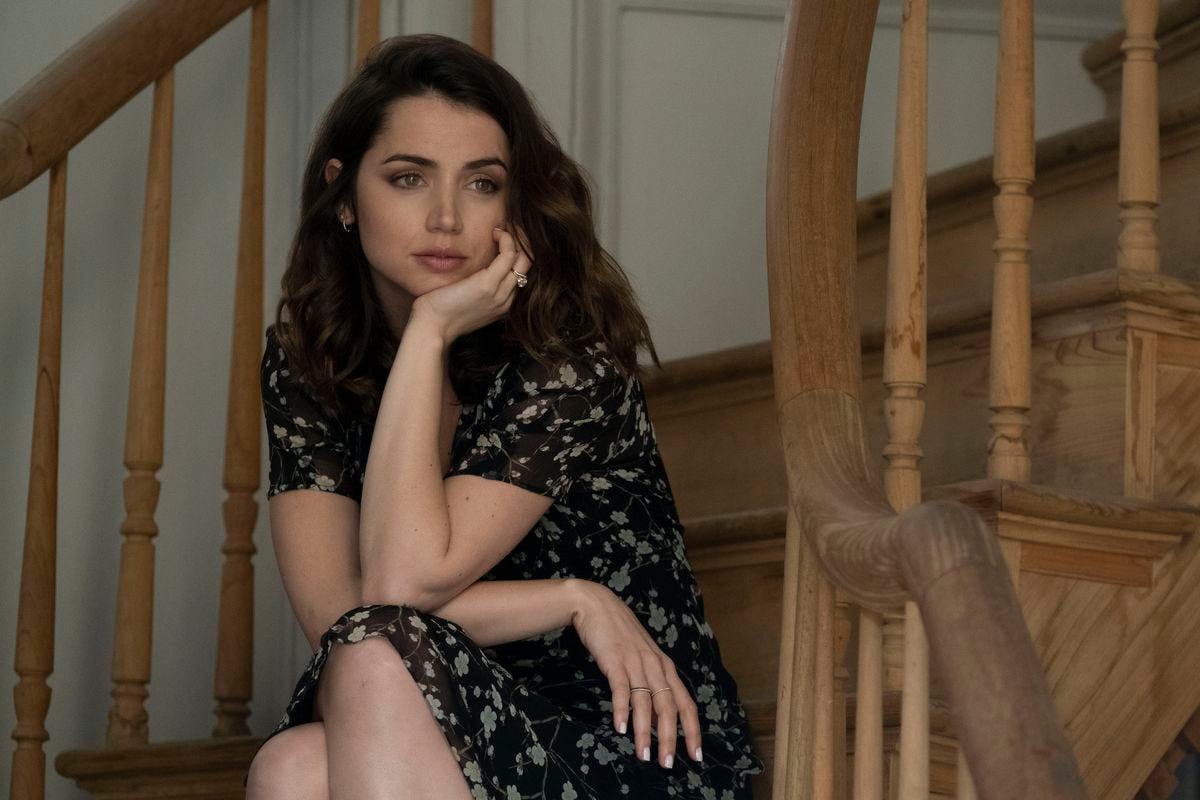 Ana De Armas sitting on a stairwell with her head in her hand