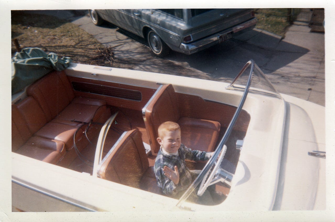 Jack and Helen rented out one side of the two car garage to the Rita Boys (Mary Rita cleaned house for Helen ) so they could store their outboard motor boat over the winter. They lived in Dorchester and needed a place to put it. Chris Daly engaged with them, loved boats and vehicles and wangled a way to get in the Captain's seat behine the steering wheel as they trailered it out. Note that the photographer stood on the side porch of Wren St. to take this picture and Jack and temporarily moved the Daly's Rambler Classic Station Wagon, 1963 into the Schuerch's driveway. Note also that Chris appears to be wearing a familiar 'diaper around nectk' over Vicks Vapo Rup? Perhsps recovering from a Strepp Throad?