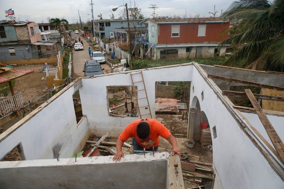 Miguel Martinez descended a ladder on his now roofless home after Hurricane Maria in Toa Baja, Puerto Rico on Sept. 30, 2017.