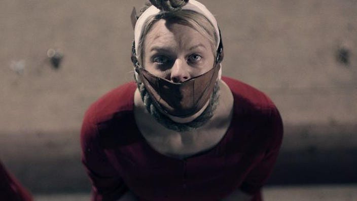 Picture from The Handmaid's Tale showing Offred gagged and with a noose around her neck. 
