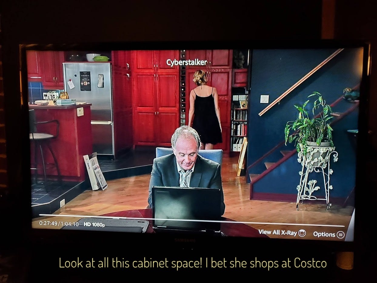 Aiden standing in front of her huge pantry while Page works on his laptop, captioned "Look at all this cabinet space! I bet she shops at Costco"