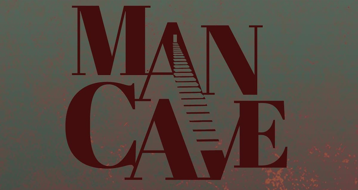 The words "Man Cave" written in all-caps dark red font. A door opens on the letter A and steps go down all the way to the letter V.