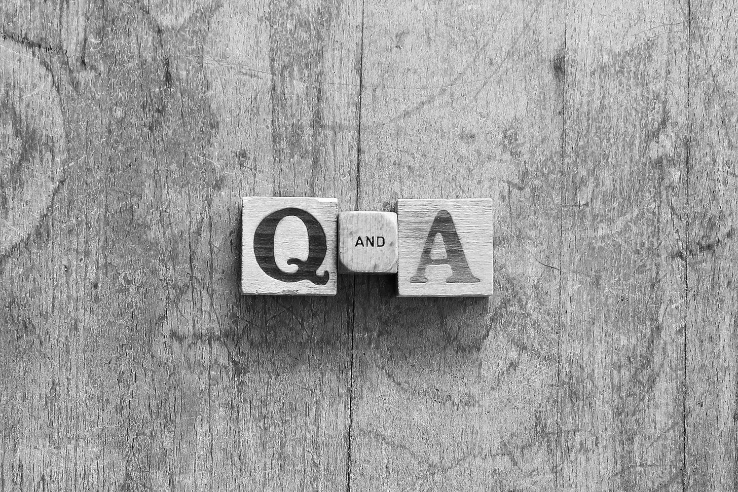 A Q&A symbol sits on a grey desk top.