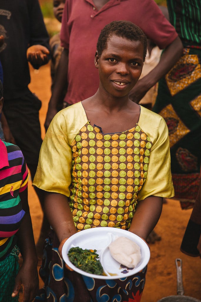Woman Holding a Plate of Food in Malawi