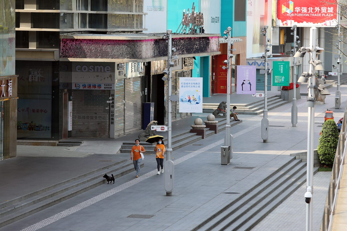 SHENZHEN, CHINA - MARCH 14 2022: Two women walk by closed shops in Huaqiangbei area, the world's biggest electronics market, in Shenzhen in south China's Guangdong province Monday, March 14, 2022. The city, an economic powerhouse bordering Hong Kong, went into the Covid-19 lockdown on Sunday. (Photo credit should read Feature China/Future Publishing via Getty Images)
