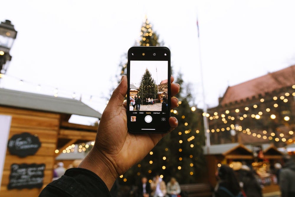 person taking photo of Christmas tree