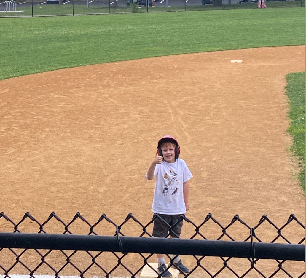 Seven-year-old giving a thumbs-up from the field.