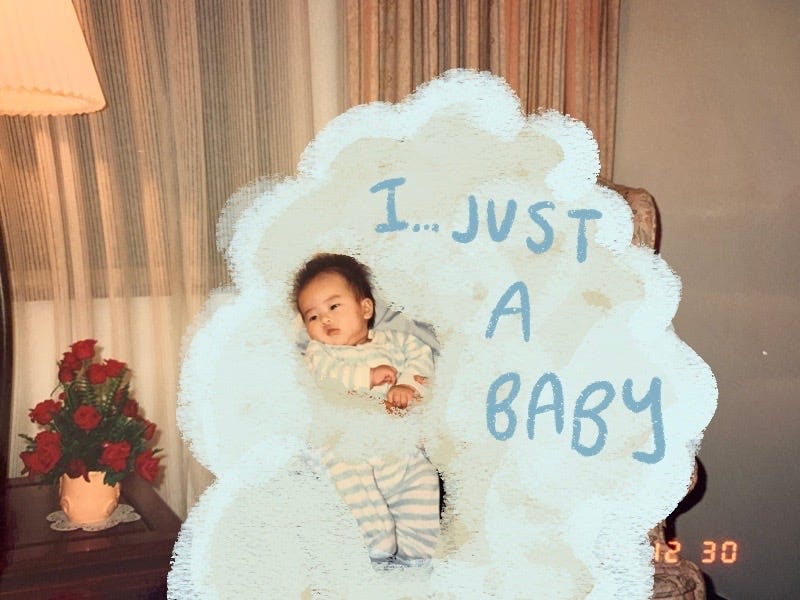 Little Asian baby wrapped in a cloud with the text saying "I...just a baby" written over the cloud