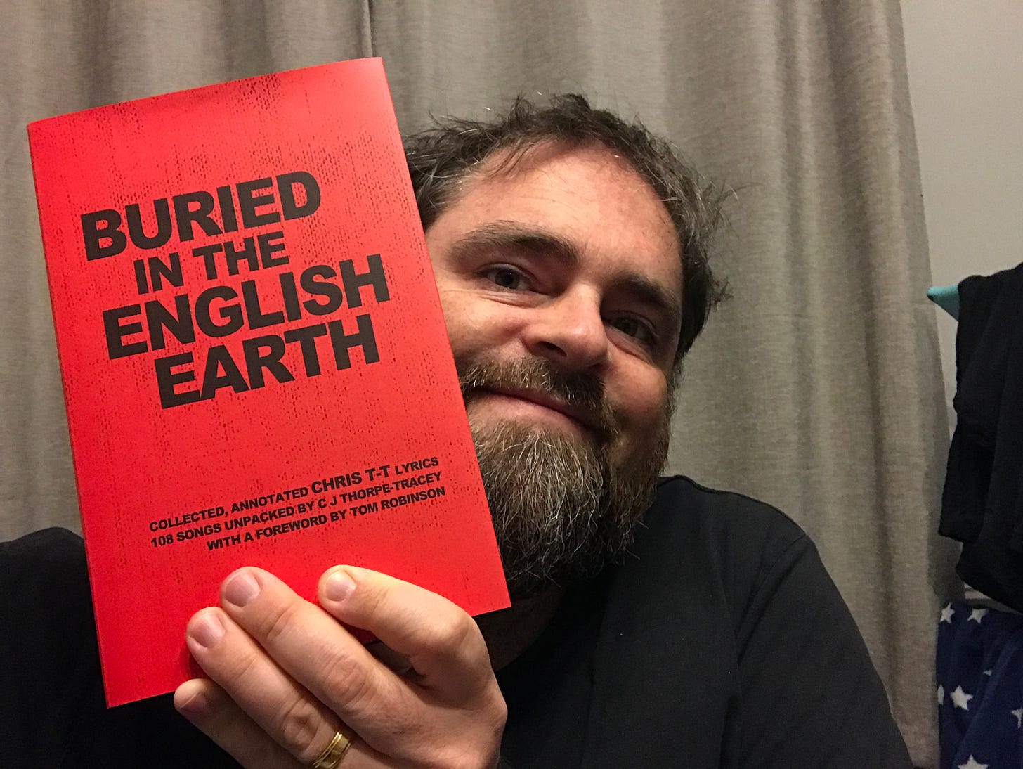 Chris holding a copy of his new lyric book Buried In The English Earth
