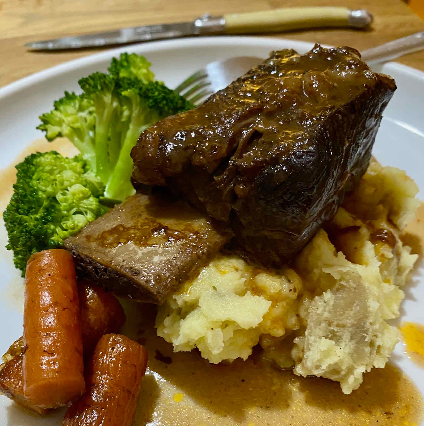 Braised short rib on a bed of mashed potato, with carrots and broccoli