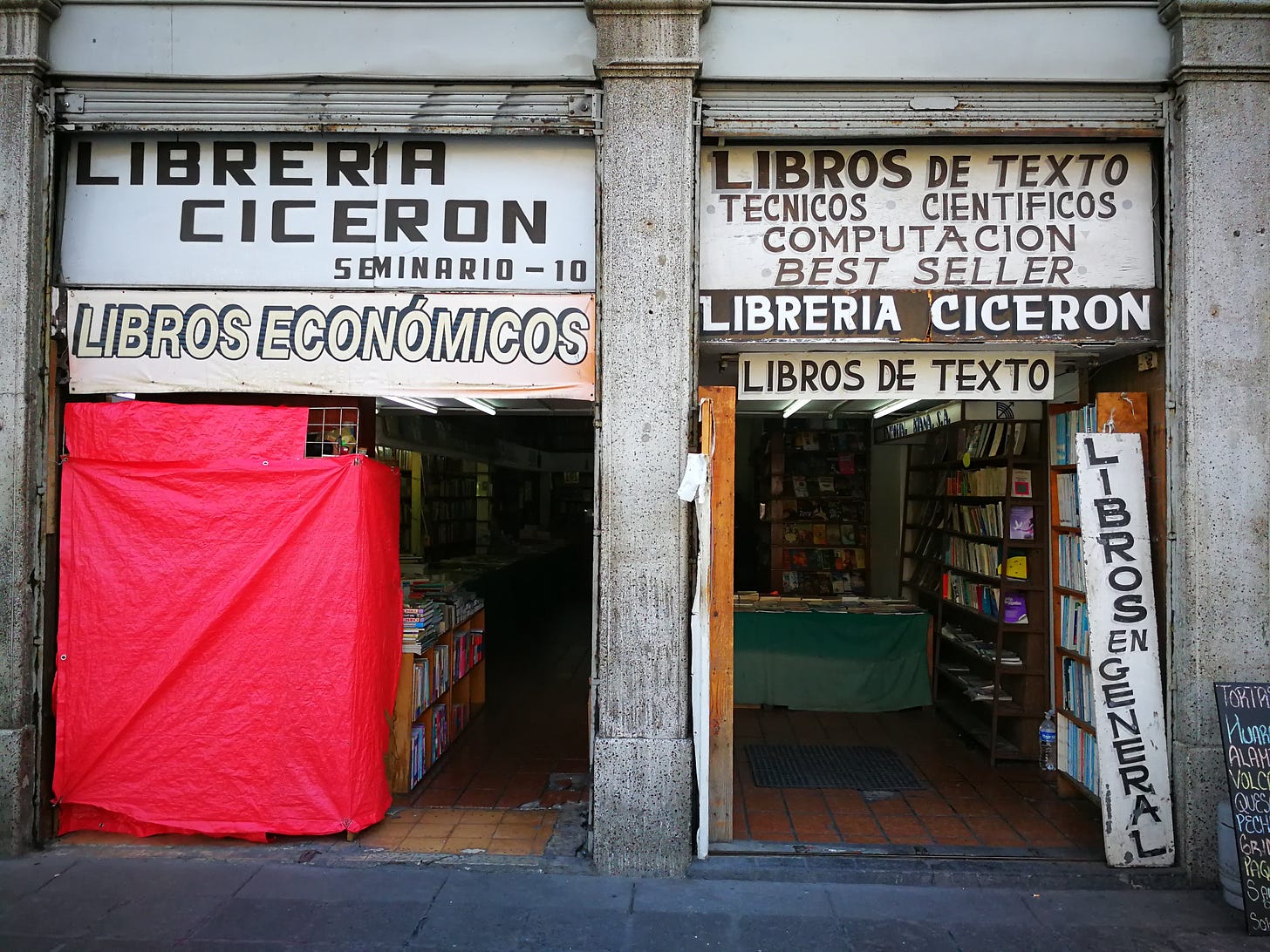 A secondhand bookshop in Mexico City, offering Libros Economicos (cheap books) Libros de Texto (textbooks) and Libros En General which you probably get the idea. The shop is open-fronted and you can see shelves extending far back into the darkness within