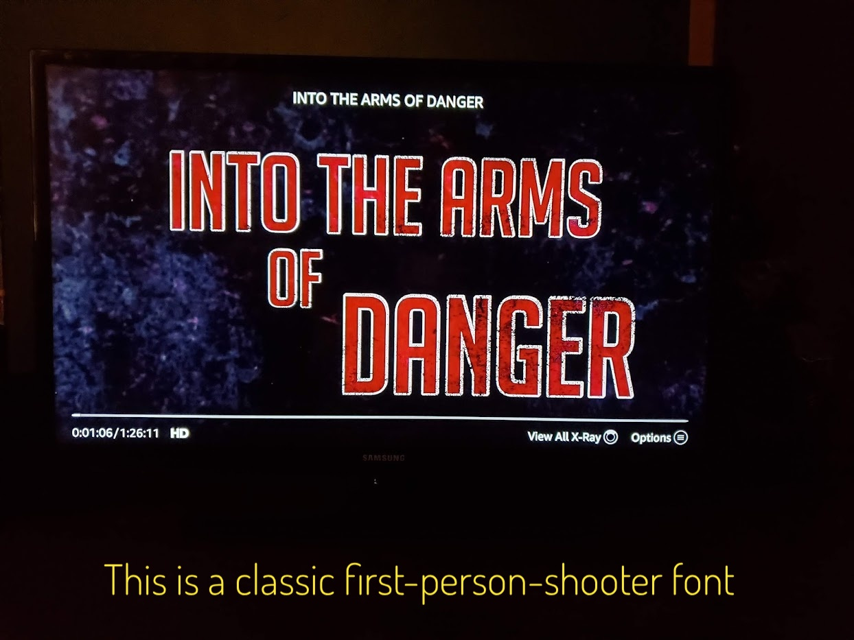 The title of the movie, in a red sans serif font outlined in white, captioned "this is a classic first-person-shooter font"