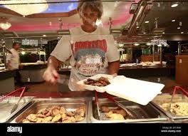 Anne Adaway fills a to go box with food for a neighbor at the Chinese Grand  Buffet in Nederland, Texas which is one of the few places in town still  open. She